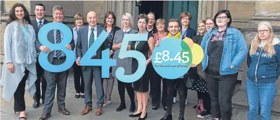  ?? Picture: Steve Brown. ?? Holding the numbers are, from left, economy secretary Keith Brown, Wise Group chief executive Laurie Russell, Living Wage accreditat­ion officer Lynn Cunningham and Mark Sanderson with members of the Wise Group and Living Wage team.