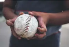  ?? AAron Ontiveroz, The Denver Post ?? Lorenzo Gonzales, 10, holds a well-used ball that occasional­ly finds its way onto the street and into a field.