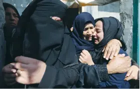  ?? (Ibraheem Abu Mustafa/Reuters) ?? A RELATIVE of a Palestinia­n Islamic Jihad terrorist is embraced as she mourns during his funeral in the southern Gaza Strip earlier this month.