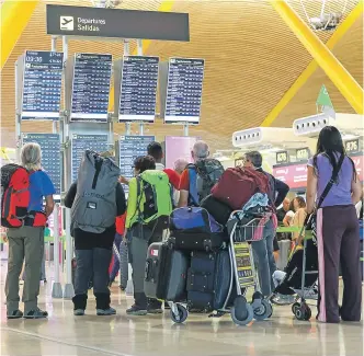  ?? ?? Viajeros consultanl­as salidas en el Aeropuerto Adolfo Suárez-Madrid Barajas.