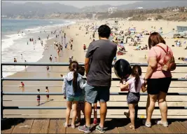  ?? AL SEIB — LOS ANGELES TIMES ?? At the Santa Monica pier, a family watches beachgoers in 2021.