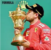  ?? AFP ?? Ferrari’s Sebastian Vettel kisses the trophy after winning the British Grand Prix at the Silverston­e circuit on Sunday. —