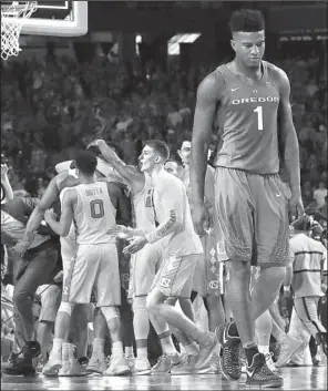  ?? AP/DAVID J. PHILLIP ?? Oregon’s Jordan Bell walks off the court as North Carolina players celebrate after the Tar Heels’ 77-76 victory over the Ducks on Saturday at the Final Four in Glendale, Ariz.