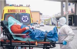  ?? OMAR MARQUES/AP ?? Paramedics rush a COVID-19 patient into a hospital Sunday in Bochnia, Poland. More than 55,000 people have died of the virus in Poland.