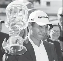  ??  ?? Xander Schauffele hoists the trophy after winning the Greenbrier Classic PGA Tour golf tournament on Sunday in White Sulphur Springs, W.Va.