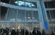  ?? Picture: AFP/ KAZUHIRO NOGI ?? MASSIVE ATTACK: Gamers play a ‘Space Invaders’ GigaMax video game displayed hugely on the windows of the Roppongi Hills observator­y in Tokyo