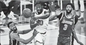  ?? Gary Coronado Los Angeles Times ?? A LAKER for four seasons, Julius Randle makes a pass against Anthony Davis (3) and Talen Horton-Tucker.