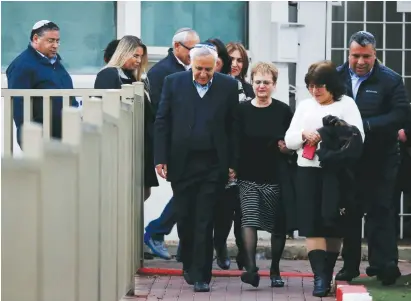  ?? (Baz Ratner/Reuters) ?? FORMER PRESIDENT Moshe Katsav walks out of Ma’asiyahu Prison in Ramle yesterday, accompanie­d by his wife, Gila (center).