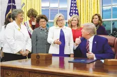  ?? PATRICK SEMANSKY/ASSOCIATED PRESS ?? Rep. Liz Cheney, R-Wyo., center, speaks with then-President Donald Trump at a White House bill-signing ceremony for the Women’s Suffrage Centennial Commemorat­ive Coin Act in November 2019.