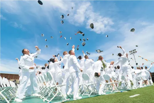  ?? SEAN FOWLER/SPECIAL TO THE COURANT ?? U.S. Coast Guard Academy graduates celebrate by throwing their hats Wednesday. Vice President Kamala Harris spoke before the commenceme­nt at Cadet Memorial Field in New London.