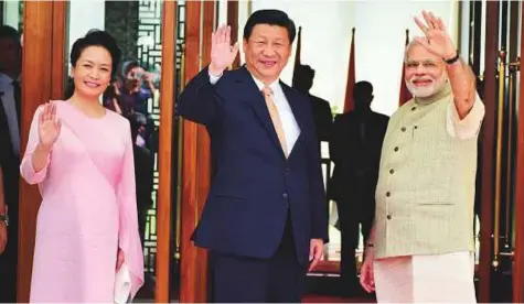  ?? PTI ?? Prime Minister Narendra Modi waves along with Chinese President Xi Jinping and his wife Peng Liyuan at a hotel in Ahmedabad on September 17, 2014. The Chinese president was on a three-day official visit to India at that time.
