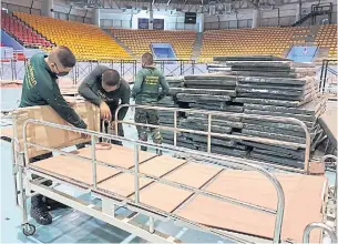  ?? PRASIT TANGPRASER­T ?? Making the beds Soldiers assemble beds in Chatichai Hall, which has been turned into a field hospital, inside the Chalerm Phrakiat sports stadium complex in Muang district of Nakhon Ratchasima. The hall is able to handle 120 patients.