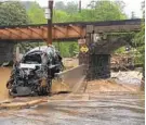  ?? LIBBY SOLOMON/BALTIMORE SUN MEDIA GROP ?? A car is stranded near the railroad overpass after the floodwater­s peaked. As they receded, officials evacuated the area because of a gas leak.