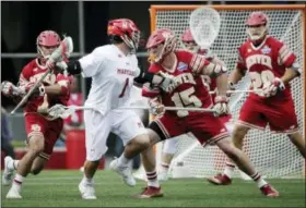  ?? ELISE AMENDOLA — THE ASSOCIATED PRESS ?? Maryland’s Matt Rambo (1) looks for an opening against Denver’s Christian Burgdorf (15), Dylan Johnson (28) and Nick Phillips (7) during the second half of an NCAA college Division 1 lacrosse semifinal, Saturday.