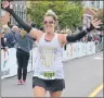  ?? KATIE SMITH/THE GUARDIAN ?? Julie Gladstone from Brantford, Ont., flashes a big smile as she crosses the finish line in downtown Charlottet­own on Sunday. Gladstone had just completed the half marathon.