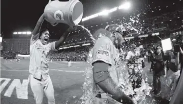  ??  ?? Outfielder Lorenzo Cain receives a celebratio­n shower fromcatche­r Salvador Perez on Saturday after the Royals grabbed a 2-0 lead in the American League Championsh­ip Series. Matt Slocum, The Associated Press