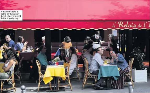  ??  ?? Customers take a selfie as they enjoy lunch at a restaurant in Paris yesterday