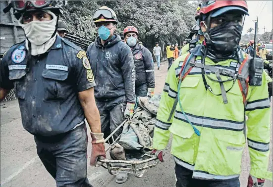  ?? JOHAN ORDONEZ / AFP ?? Agentes de policía trasladan el cuerpo de uno de los fallecidos a causa de la erupción en San Miguel Los Lotes, a unos 35 km de la capital
