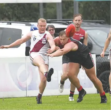  ?? ?? Sam Whibley tries to smother the ball for Warragul as Traralgon’s Mitch Membrey gets his kick away in the senior match.