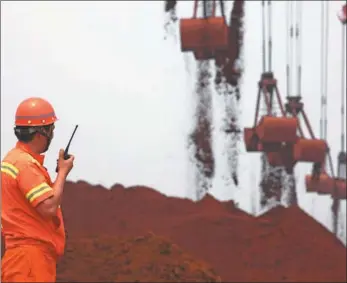  ?? PROVIDED TO CHINA DAILY ?? A dockworker supervises the unloading of iron ore at Qingdao Port in Shandong province.