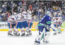  ?? DARRYL DYCK, THE CANADIAN PRESS ?? Edmonton Oilers celebrate Evan Bouchard’s winning goal on Friday night as Vancouver Canucks goalie Arturs Silovs skates off the ice.