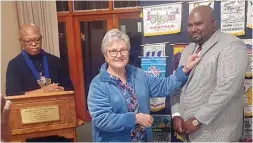  ?? ?? Rotary Club of Polokwane president elect Susan van der Merwe, presents new club member Geshim Francis with his pin while club president Mxolisi Bambo (left) looks on.