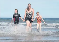  ?? Picture: Kim Cessford. ?? From left: Bella Card, 9, Cheryl Card, and Emily Musson, 9, cool off at the West Sands in St Andrews yesterday.