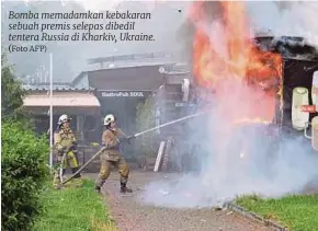  ?? (Foto AFP) ?? Bomba memadamkan kebakaran sebuah premis selepas dibedil tentera Russia di Kharkiv, Ukraine.