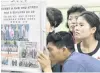  ?? PHOTO: KYODO/VIA REUTERS ?? North Koreans look at displayed newspapers in a Pyongyang subway station yesterday reporting the summit between the US and North Korea.