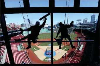  ?? (MATT STONE/BOSTON HERALD) ?? Window washers clean the NESN booth glass during the final preparatio­ns for 2023 Opening Day at Fenway Park in Boston on Wednesday, March 29, 2023.