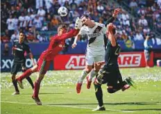  ?? AP ?? Los Angeles Galaxy’s Zlatan Ibrahimovi­c (centre right) heads the ball for a goal, his second goal of the game, against Los Angeles FC goalkeeper Tyler Miller on Saturday.