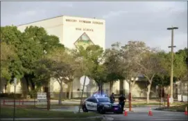  ?? MIKE STOCKER — SOUTH FLORIDA SUN-SENTINEL VIA AP, FILE ?? Police watch the entrance of a parking lot at Marjory Stoneman Douglas High School in Parkland, Fla.