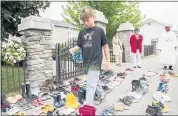  ?? GRAHAM HUGHES — THE CANADIAN PRESS VIA AP ?? Jamieson Kane puts down tobacco as a tribute to all the victims of the residentia­l school system as he walks amongst children’s shoes outside St. Francis Xavier Church in Kahnawake, Quebec, Sunday.