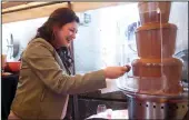  ??  ?? Jessica Lopez of Delhi covers her strawberry in chocolate at Jessie’s Grove Winery during the Wine and Chocolate weekend in Lodi on Feb. 9, 2019.