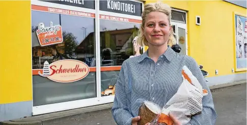  ?? ?? Peggy Röllig mit Brot und Brötchentü­te vor der Bäckerei Schwerdtne­r im Nettogebäu­de. Sie gönnt sich und ihrer Familie das backfrisch­e Frühstück – etwas besonders Schönes, sagt sie..