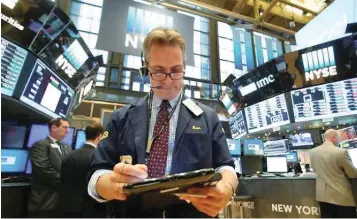  ?? — Reuters ?? Traders work on the floor of the New York Stock Exchange (NYSE) in New York City.