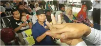  ?? HANUNG HAMBARA/JAWA POS ?? GOSOK SELA JARI: Petugas KAI memperagak­an cara mencuci tangan yang benar di Stasiun Pasar Senen, Jakarta, kemarin (9/3).