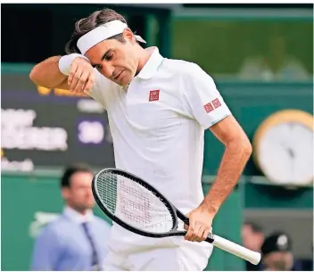  ?? FOTO: AP/KIRSTY WIGGLESWOR­TH ?? Roger Federer wischt sich im Match gegen Hubert Hurkacz in Wimbledon den Schweiß von der Stirn. Das Viertfinal-duell gegen den Polen verlor Federer im Juli.