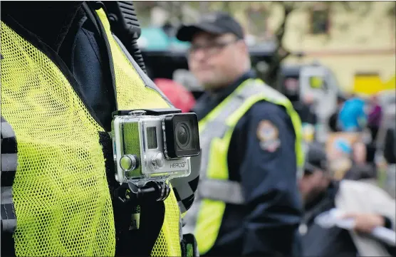  ?? — THE CANADIAN PRESS FILES ?? A Vancouver police officer wears a chest-mounted camera as he oversees the takedown of a tent city in Oppenheime­r Park last October. Victoria police chief Frank Elsner thinks mandatory cameras on police uniforms are inevitable.