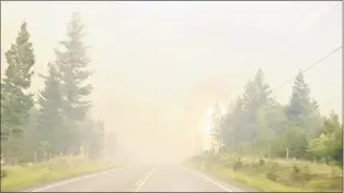  ?? TWITTER/SALLY AITKEN VIA CP ?? A wildfire burns by the side of the highway in British Columbia’s West Chilcotin region in this handout photo taken from video.