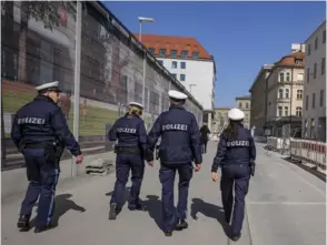  ?? AP ?? Cuatro policías vigilaron una calle que se encontraba casi vacía en el centro de Múnich, Alemania, la tarde de este sábado.