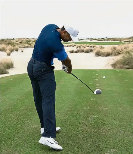  ?? — AFP ?? Blast off: Tiger Woods hitting his tee shot on the third hole during Monday’s practice round of the Hero World Challenge golf tournament at Albany.