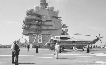  ??  ?? Trump (centre) is welcomed aboard the USS Gerald R Ford in Norfolk, Virginia. — AFP photo