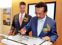  ??  ?? Chief Minister Datuk Seri Musa Aman signing a glass plaque to mark the opening of Plaza Shell, watched by Shell Malaysia Chairman Datuk Iain Lo (left), who is also Managing Director of Sarawak Shell Berhad and Sabah Petroleum Co Ltd.