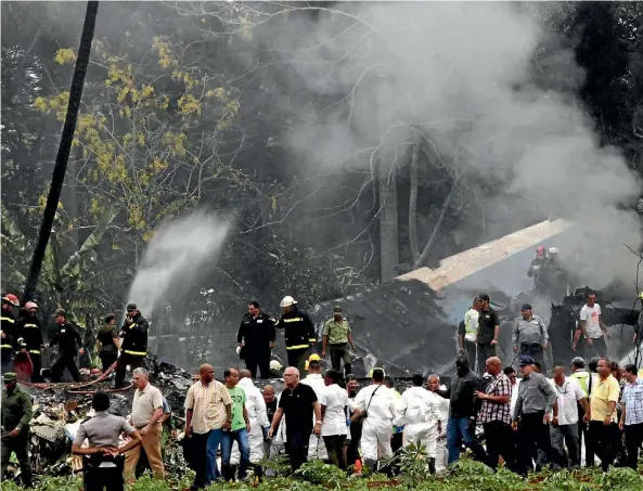  ??  ?? Cuba’s President Miguel Diaz-Canel, third from left, walks away from the site where a Boeing 737 crashed with more than 100 passengers on board just after takeoff from Havana’s internatio­nal airport.