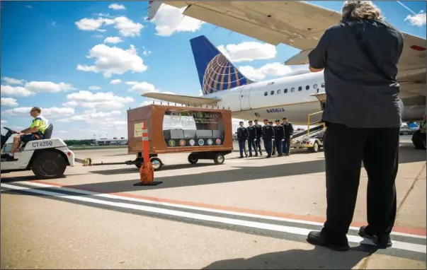  ?? (AP/The Philadelph­ia Inquirer/Lauren Schneiderm­an) ?? Craig Wilkins, the nephew of Cpl. Paul Wilkins, takes photograph­s June 23 as the remains of his uncle are deplaned and put into a dignified remains cart at Pittsburgh Internatio­nal Airport in Pittsburgh.
