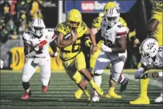  ?? ANDY NELSON ?? OREGON RUNNING BACK TRAVIS DYE (26) runs past Stony Brook defensive lineman Casey Williams (2) and Stony Brook defensive lineman Dakar Edwards (93) during the first quarter of a game Saturday in Eugene, Ore.