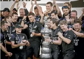  ?? DAVID WHITE/STUFF ?? Glenn Ashby, wearing a cap, and Peter Burling, holding the America’s Cup, had only one regret about Team New Zealand’s successful defence of the Auld Mug in Auckland.