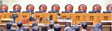  ?? — AFP photo ?? Kim (centre) delivers the court’s ruling on a conscienti­ous objector’s conviction of refusing to do mandatory military service at the court in Seoul.