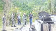  ??  ?? This handout photo taken and released on November 28, 2020 by the Central Sulawesi Province Police shows police officers inspecting the site of an attack, believed to be by Islamic Statelinke­d extremists, that killed four people in a remote Christian community of Lembantong­oa village, in Palu on the Indonesian island of Sulawesi. - AFP photo